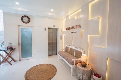 瑞诗凯诗Terrakotta Rishikesh的更衣室,墙上设有长凳和时钟