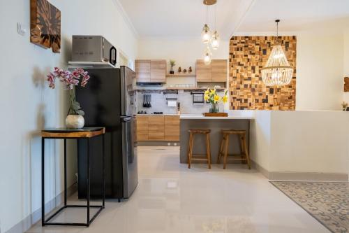 科贾扬Siji Plemburan Vacation Home的厨房配有黑色冰箱和台面