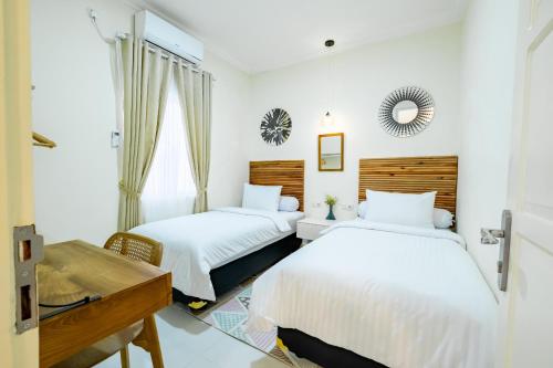 科贾扬Siji Plemburan Vacation Home的一间卧室配有两张床和镜子