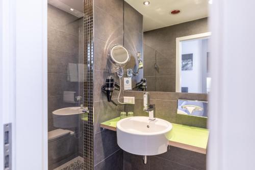 施图尔Select Hotel A1 Bremen-Stuhr的浴室设有2个水槽和镜子