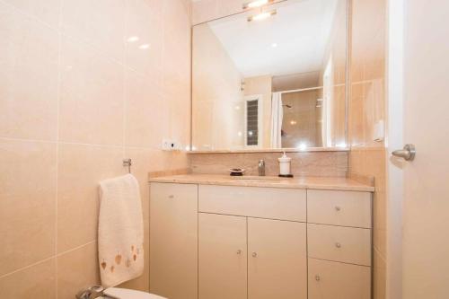 卡内·德·玛尔Maresme Beach Apartment的一间带水槽、卫生间和镜子的浴室