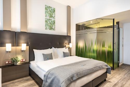 不莱梅不莱梅城市优选酒店 的一间卧室设有一张大床和一个大镜子
