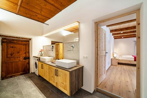 拉塞斯Unterlanpacher Historic Refugium的一间带两个盥洗盆的浴室和一扇通往卧室的门