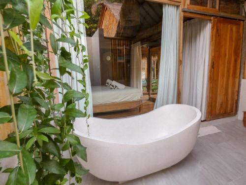 吉利阿尔La Siesta bungalows & Cuisine的浴缸位于客房中间