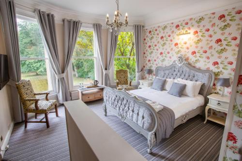 贝德福德林场庄园酒店的一间卧室配有一张带花卉壁纸的床