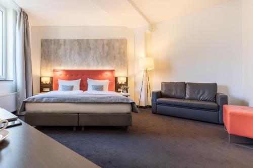 柏林Select Hotel Berlin The Wall - Apartments的酒店客房,配有床和沙发