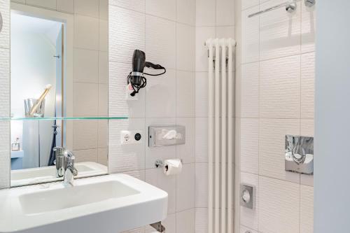 柏林柏林检查站查理精选酒店的白色的浴室设有水槽和淋浴。