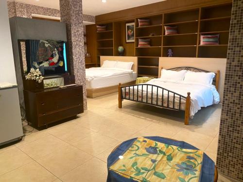 台南二姐的家的一间卧室配有两张床和一台平面电视