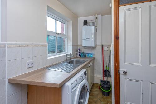 里辛Beautiful Redbrick Home in Ruthin Centre & Parking的厨房配有水槽和洗衣机