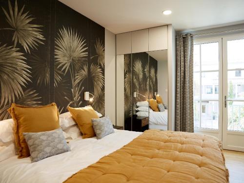圣马丹德雷加里昂酒店的一间卧室配有一张带黄色枕头的大床