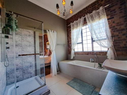 德尔斯特鲁姆Dullstroom Manor Game & Trout Lodge的带淋浴、浴缸和盥洗盆的浴室