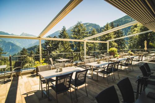 弗林肯贝格die Aussicht的餐厅配有桌椅,位于山脉的背景中