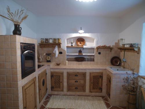 莫济列Etno House Gosteče- Suite with Finnish sauna的一个带木制橱柜和炉灶的大厨房