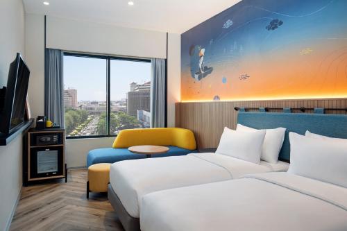 三宝垄ibis Styles Semarang Simpang Lima的酒店客房,设有两张床和一张沙发