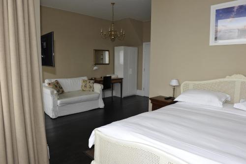 滨海绍森德苏恩诺斯旅馆的一间卧室配有一张床、一张沙发和一把椅子