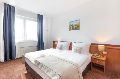 柏林Hotel Aldea Berlin的卧室配有一张带蓝色窗帘的大型白色床