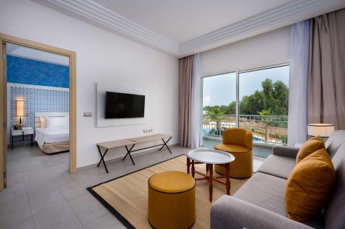 萨伊迪耶Radisson Blu Resort, Saidia Garden的客厅配有沙发和1张床