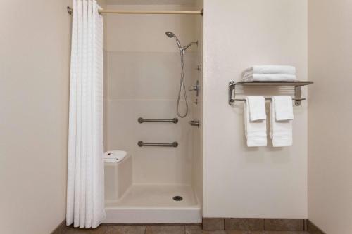 哈钦森Baymont by Wyndham Hutchinson的带淋浴、卫生间和毛巾的浴室