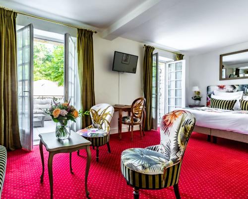莱塞齐耶德泰阿克莱桑特奈尔酒店的卧室配有一张床和一张桌子及椅子