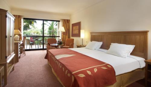 丰沙尔波尔图湾波尔图马尔酒店的酒店客房设有一张大床和一个阳台。