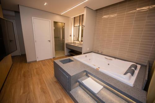 圣路易斯-贡萨加Origens Hotel的一间带浴缸的大浴室。