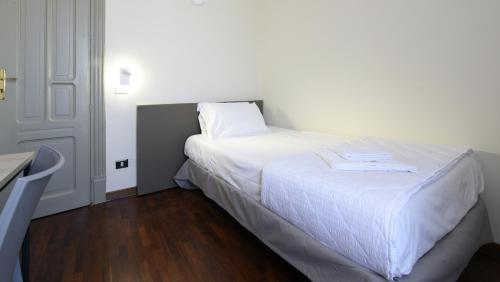 巴勒莫Hotel Roma 62的卧室配有白色床单和白色床。