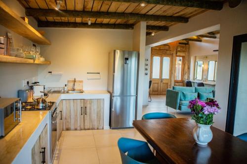 干斯拜De Uijlenes的厨房配有木桌和冰箱。