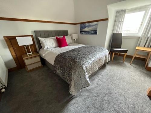 卢赫斯松林乡村别墅的一间卧室配有一张带红色枕头的大床