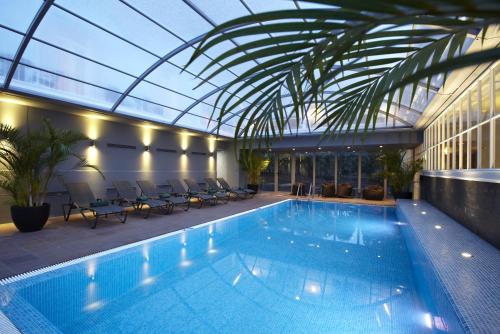 圣达塞拉塞拉高尔夫波尔图湾度假酒店的一座带玻璃天花板的建筑中的游泳池