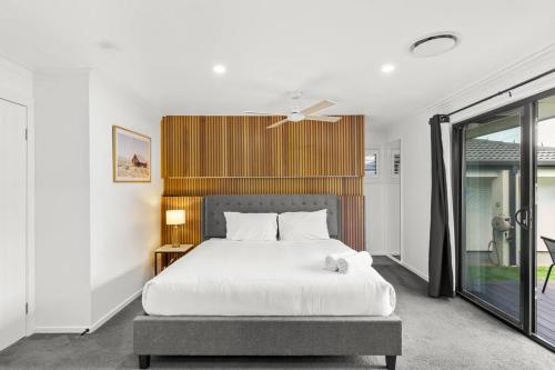 黄金海岸Ultra Modern & Relaxing Inner City 4bed House - with a Private Pool - 10mins walk to Beach的卧室配有白色的床和窗户。