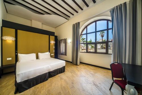 桑卢卡尔-德巴拉梅达Hotel Palacio Marqués de Arizón的一间卧室设有一张床和一个大窗户