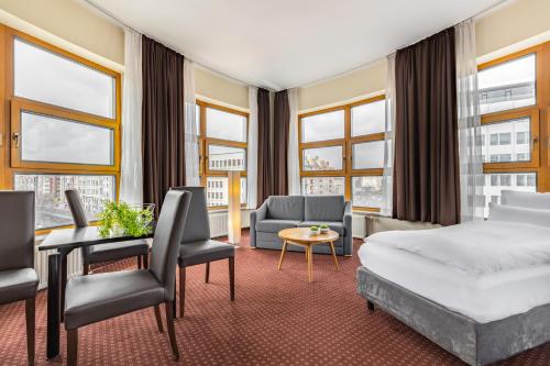 柏林柏林中央火车站诺富姆城市酒店B的酒店客房配有一张床、一张沙发和椅子。