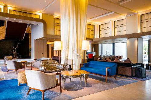 那霸嘉新酒店的酒店大堂设有蓝色的沙发和钢琴