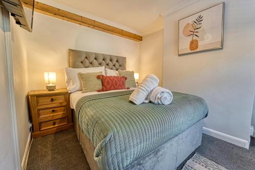 伍斯特Guest Homes - London Road Cottage的一间小卧室,配有床和床头柜