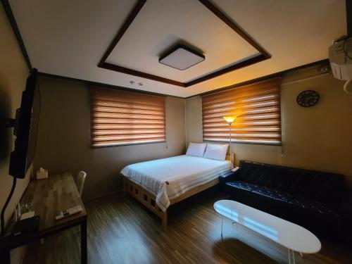 仁川市TreehouseUnseo GuestHouse的一间带床和沙发的小卧室