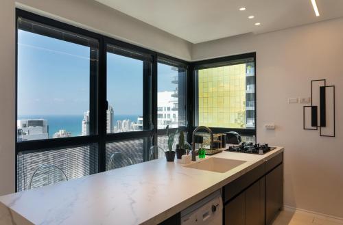 巴特亚姆YalaRent sea-breeze penthouse with jacuzzi的厨房设有大窗户,享有城市美景。