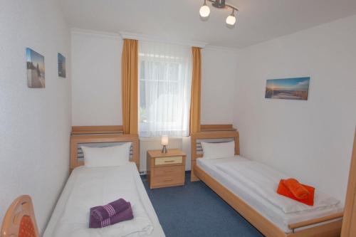 奥斯赛拜-塞林Ferienhaus zum Südstrand的客房设有两张床和窗户。