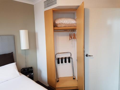 悉尼Parramatta Hotel Apartment的带衣柜、床和门的房间