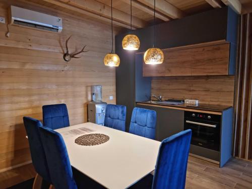 OrllanBatllava Premium Resort Villa 2的厨房配有白色的桌子和蓝色的椅子