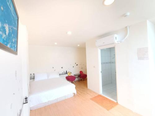 恒春古城垦丁峰晴海湾馆的白色卧室设有一张床和一个步入式淋浴间