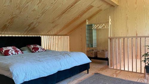 Domek na wzgórzu的一间卧室设有一张床和木制天花板