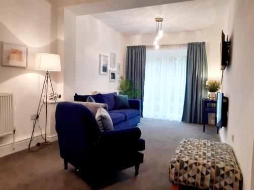 兰贝里斯No's 7 and 8 Llewelyn Apartments的客厅配有蓝色的沙发和蓝色的椅子