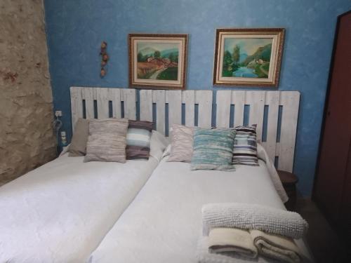 奥卡尼亚Habitación en Ocaña的卧室内配有两张单人床,墙上挂有两张照片