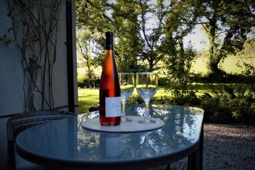 肯梅尔Remarkable Apartment in Kenmare Ireland的一张桌子上放着一瓶葡萄酒,放上两杯