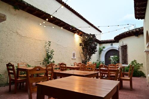 圣安娜Ricks hostel Santa Ana的庭院配有木桌、椅子和灯