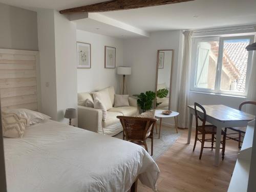 卡斯特拉讷Maison St Victor的一间卧室配有一张床、一张桌子和一张沙发