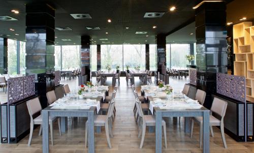Gąsawa赫巴利姆温泉酒店的用餐室配有长桌子和椅子