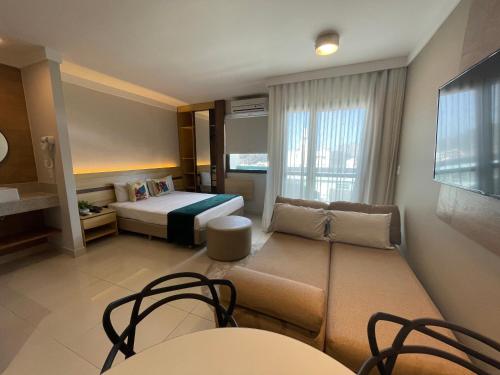 维多利亚Flat PRAIA Home Experience Dante Michelini的酒店客房带一张床、一张桌子和椅子
