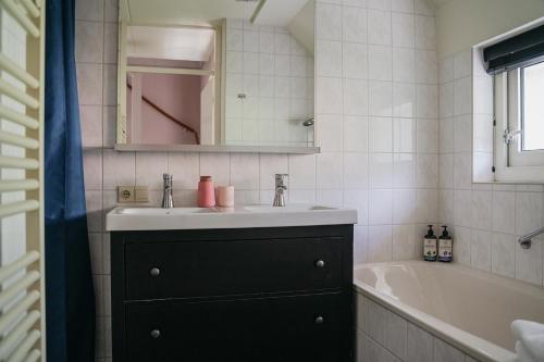 IJhorstCottage Hazenhorst - paradijs aan het bos的浴室配有盥洗盆和浴缸。