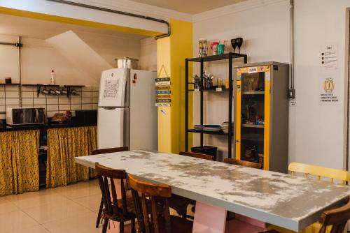 圣保罗Lamparina Hostel的厨房配有桌椅和冰箱。